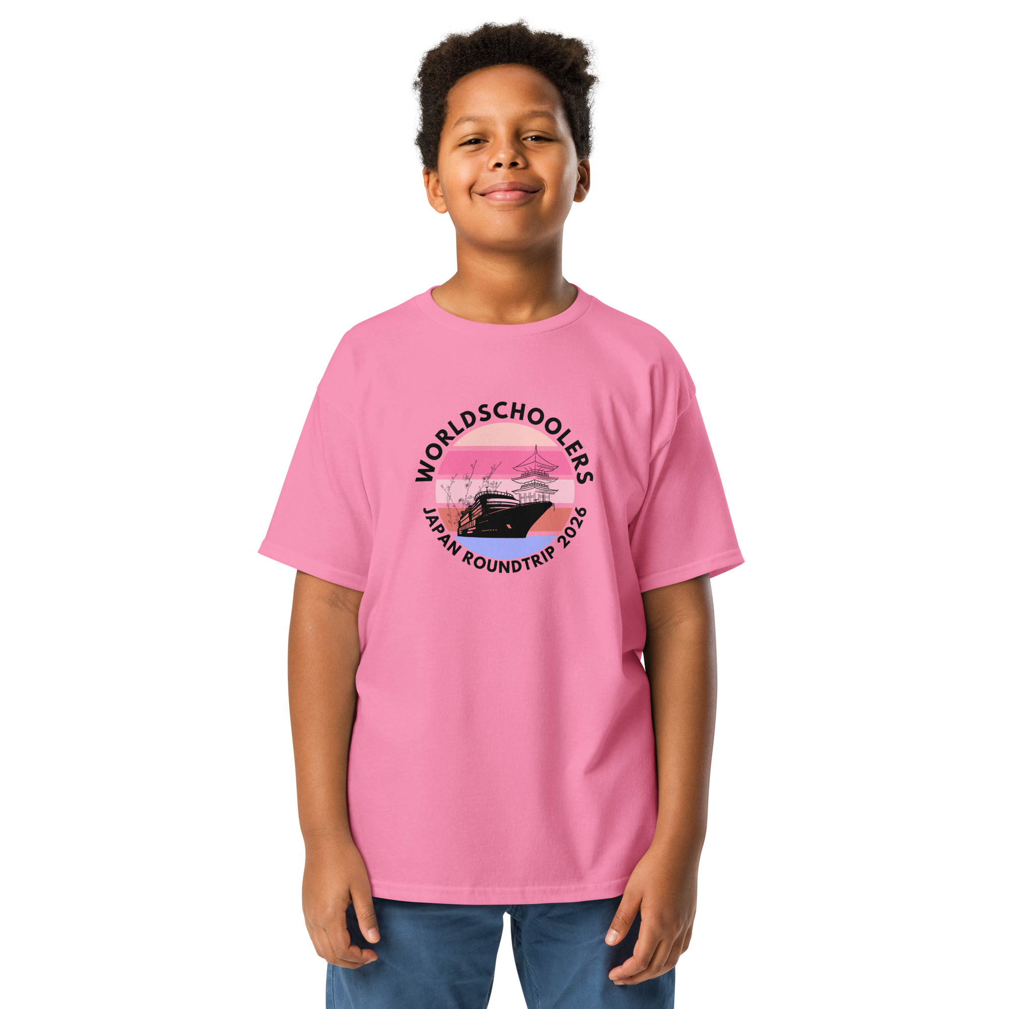 Child wearing a pink Japan Roundtrip 2026 youth graphic tee with a scenic design, perfect for travel and adventure enthusiasts.