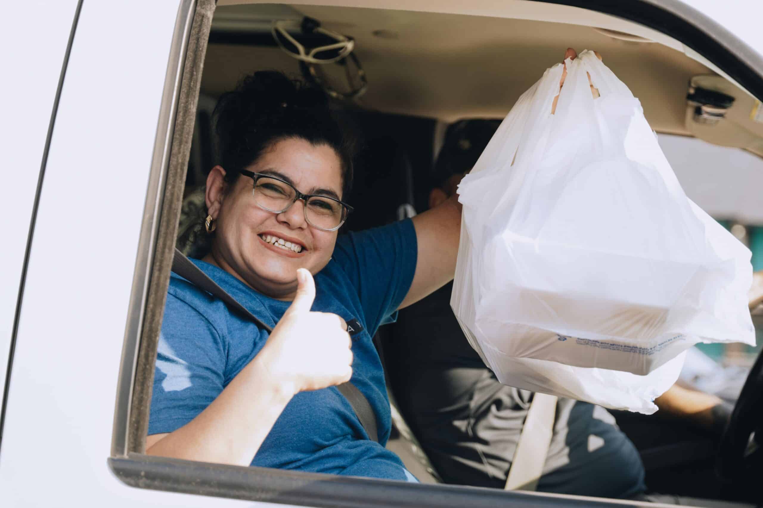 A Dallas resident receiving a hot meal through our drive-thru after a windstorm in May 2024.