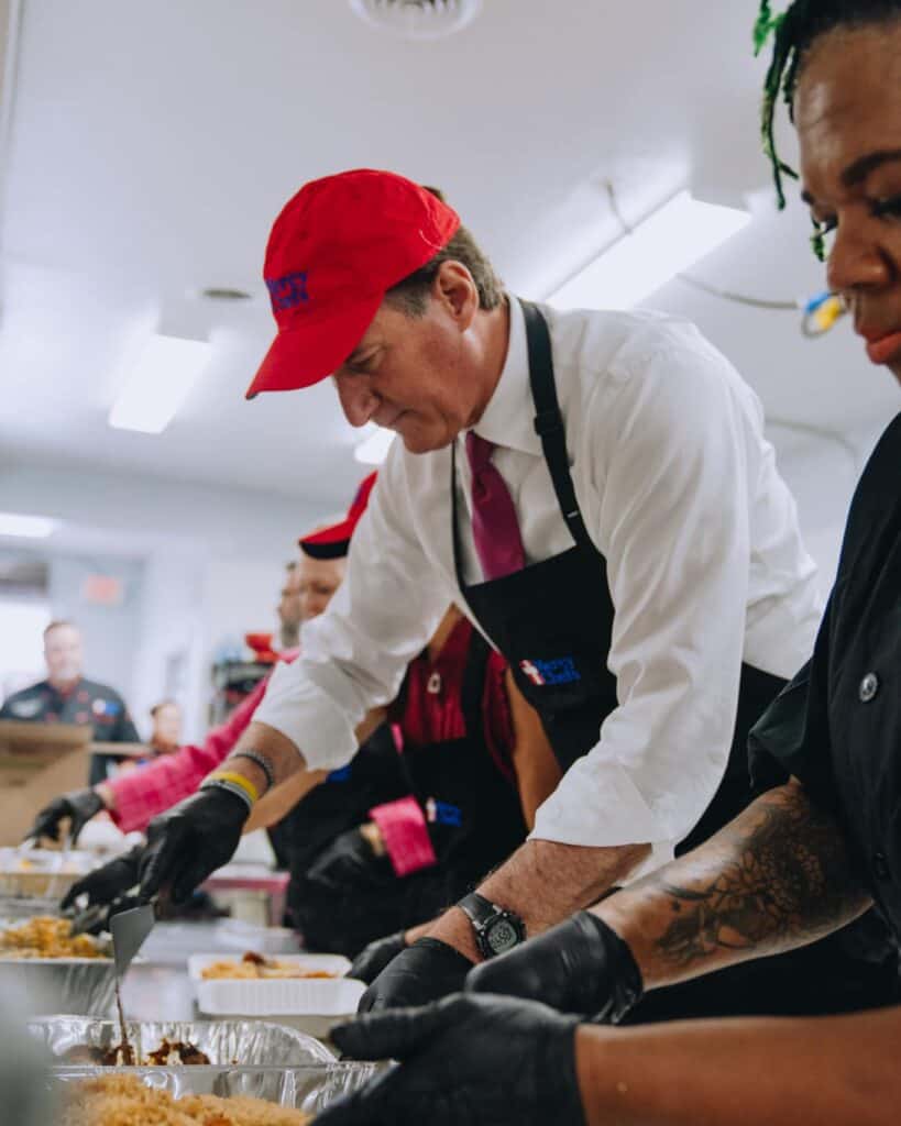 Governor Glenn Youngkin preparing a hot meal with the Mercy Chefs team.