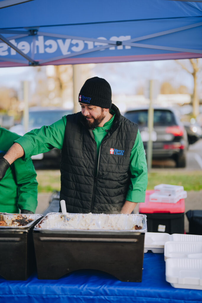 Mercy Chefs team serving hot, chef-prepared meals to attendees at the Community Christmas Giveaway in Norfolk, VA.