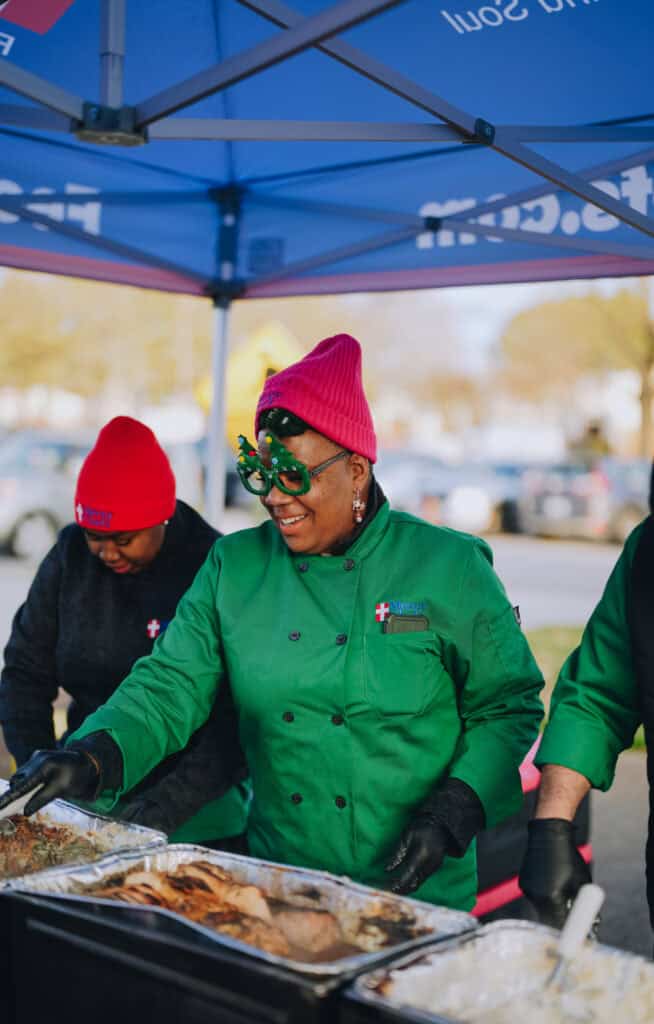 Mercy Chefs team serving hot, chef-prepared meals to attendees at the Community Christmas Giveaway in Norfolk, VA.