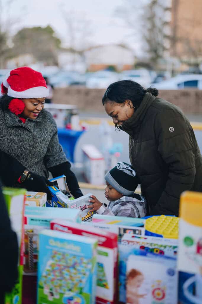 Children at the Community Christmas Giveaway in Norfolk, VA, receiving free toys.