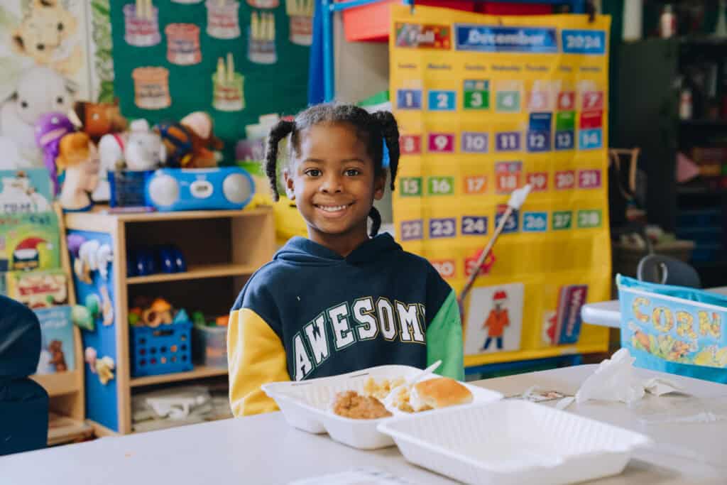 Child enjoying a hot meal at the Shaq-a-Claus event.
