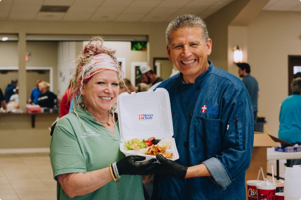 Chef Lisa and Chef Jaime holding a Mercy Chefs meal
