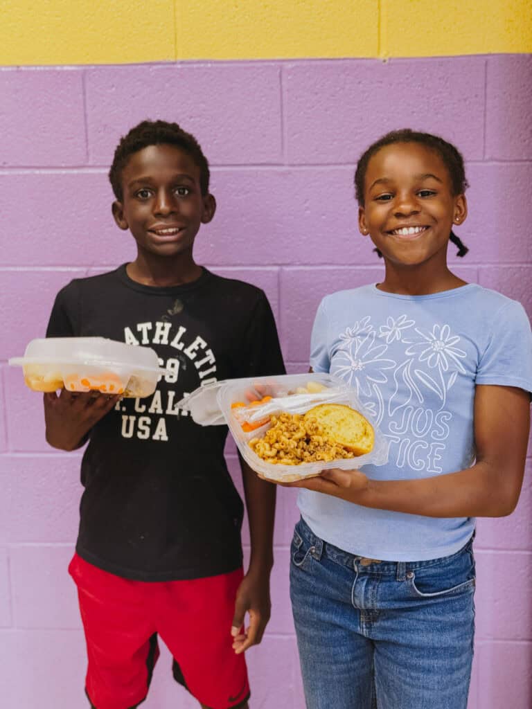 A brother and sister receiving Mercy Chefs hot meals at Jones Elementary