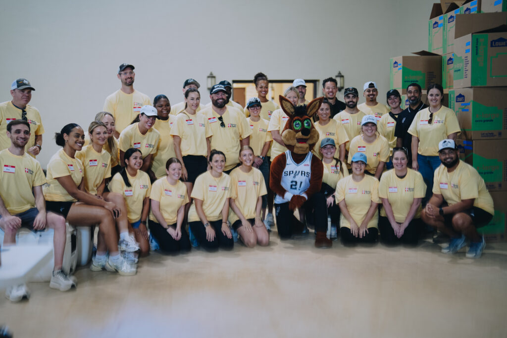 Spur employees and Mercy Chefs volunteers posing with the Spurs Coyote mascot