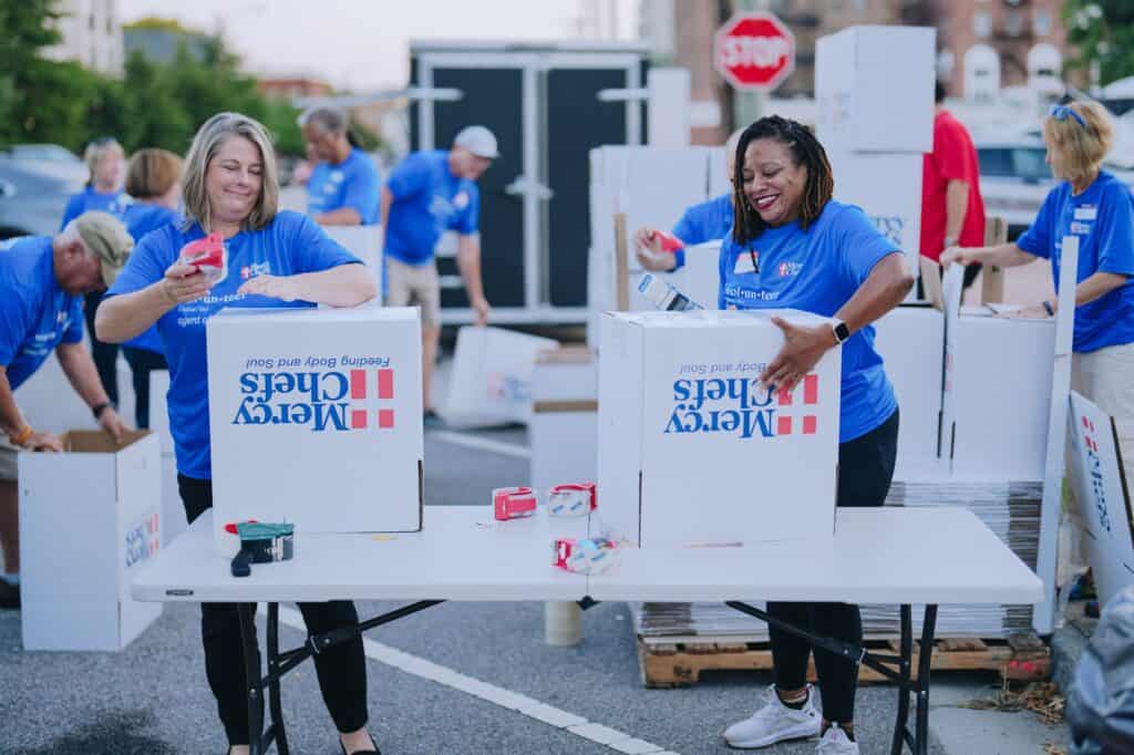 Volunteers pack groceries for families in need at Mercy Chefs' HQ