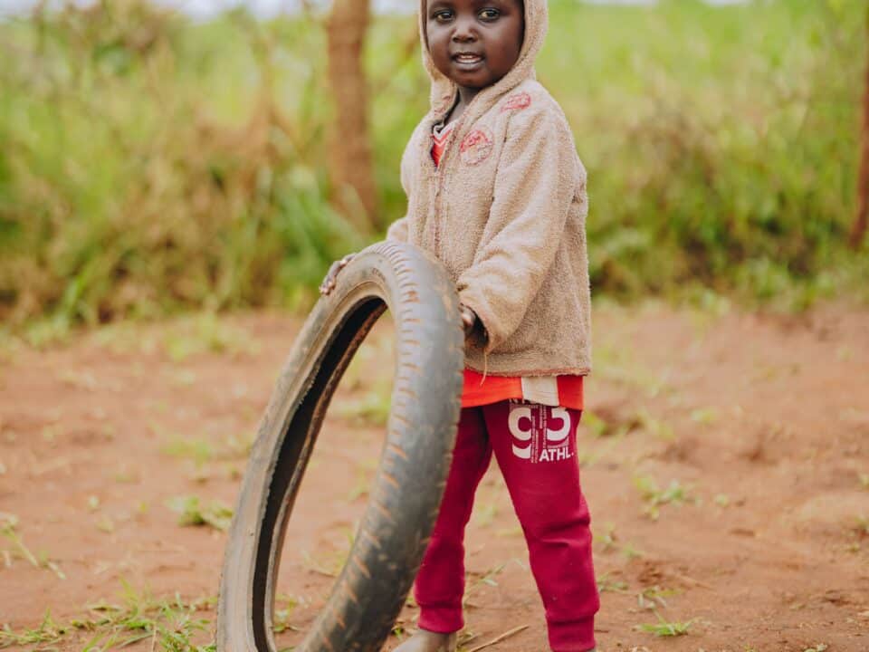 A Ugandan child holds a tire