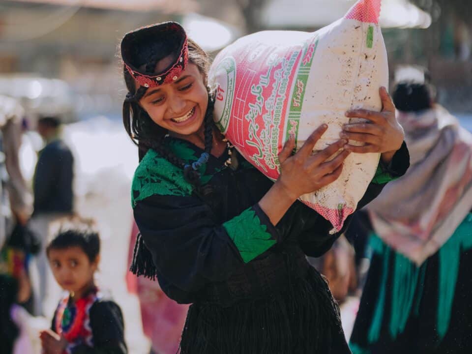 A woman receives groceries in Pakistan
