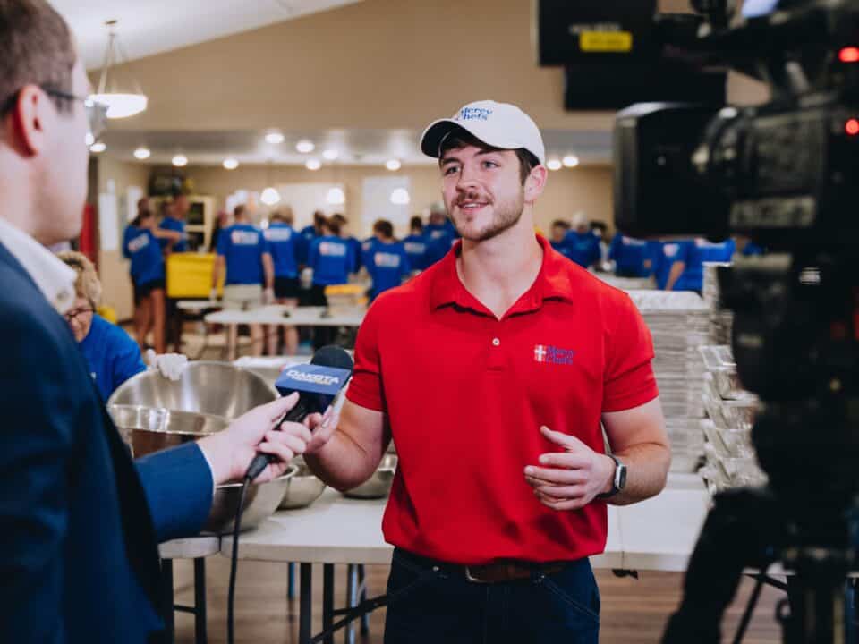 A reporter interviews Raymond LeBlanc on the ground