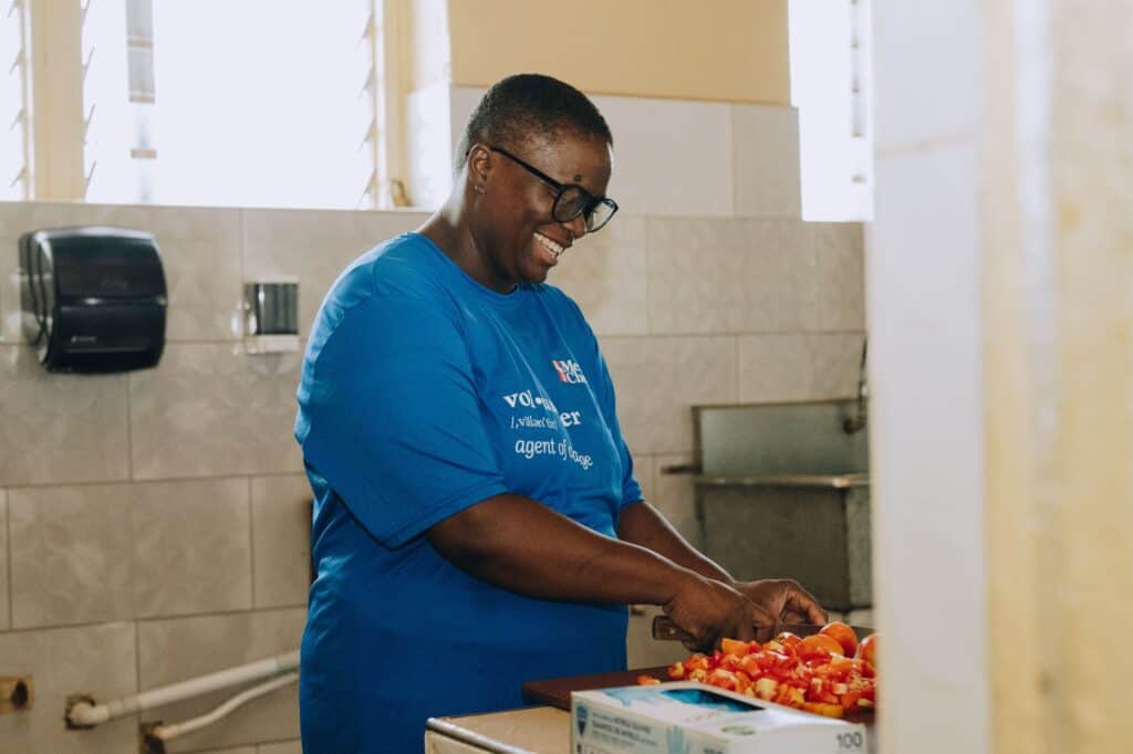 A local volunteer chops tomatoes in Jamaica