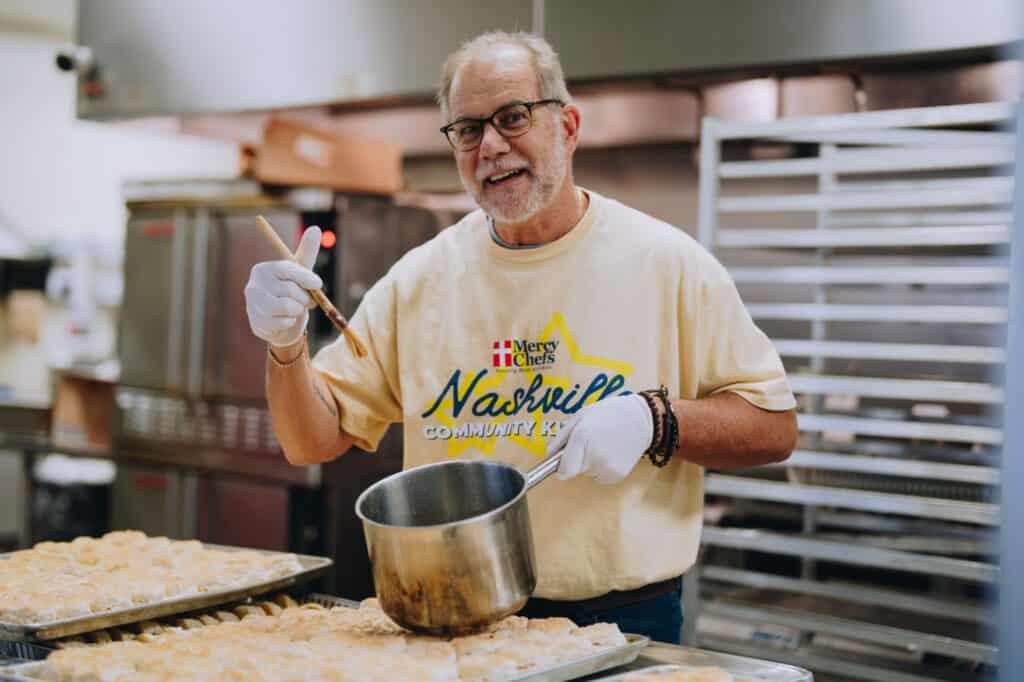 A volunteer in the Nashville Community Kitchen preparing bread for winter storm victims