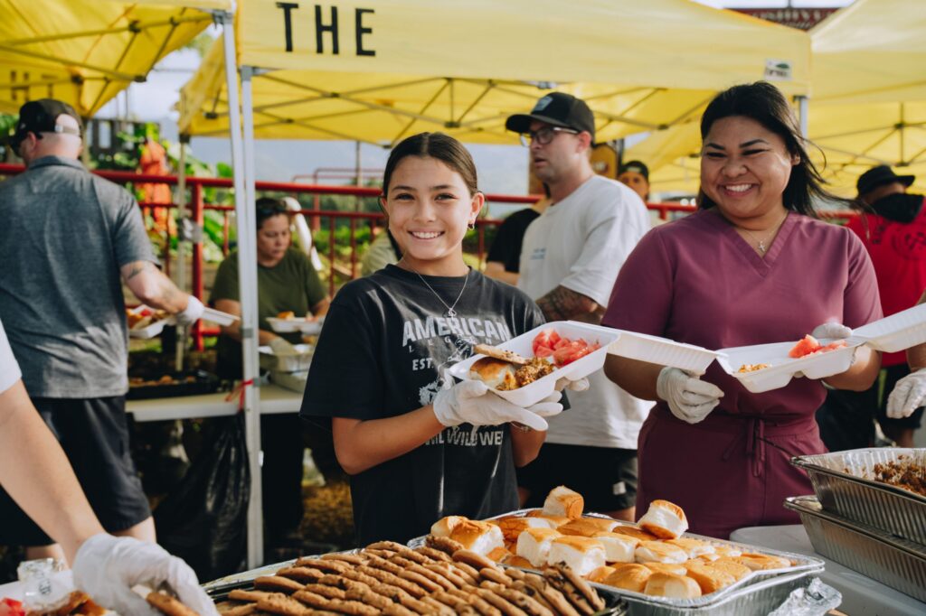 A volunteer plates meals for flood victims in Waialua, HI