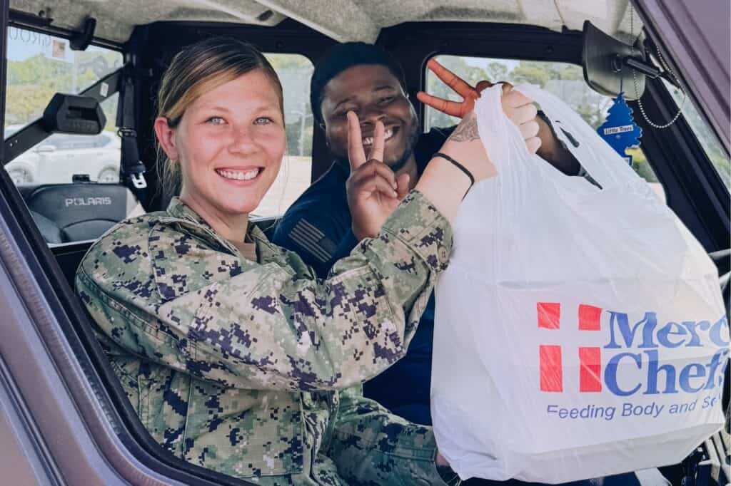 Two active-duty military members receive hot meals at Little Creek Naval Base