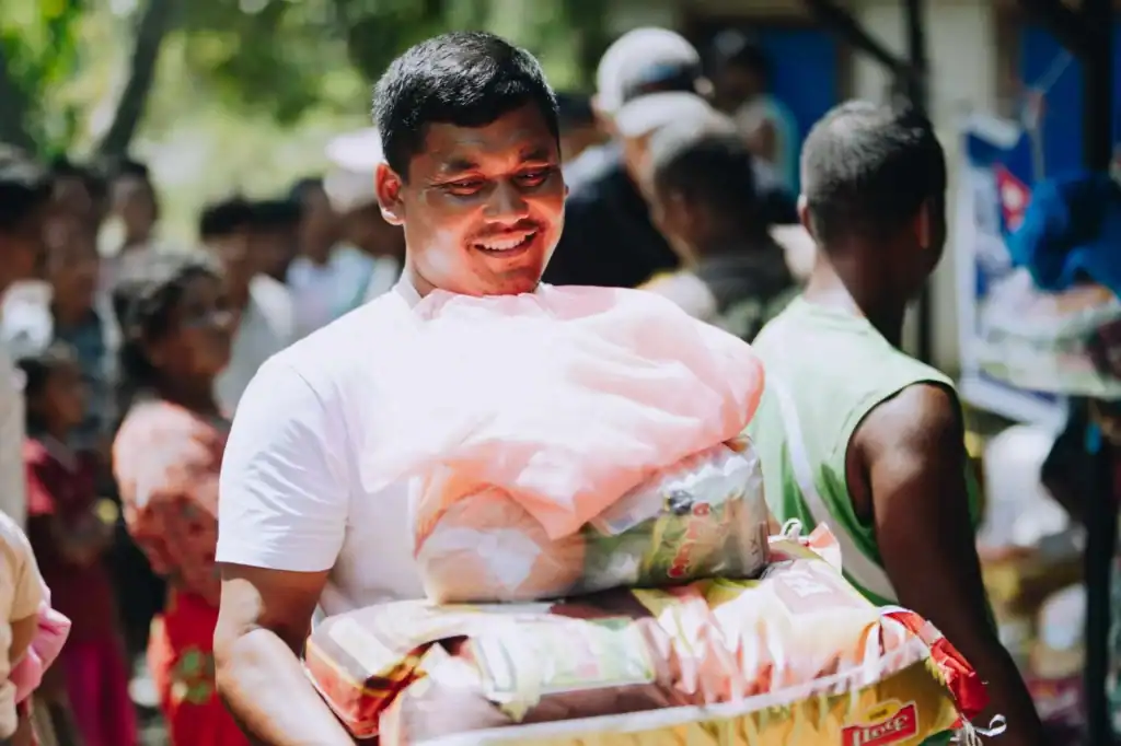 Man in Nepal smiles as he receives a Mercy Chefs grocery pack