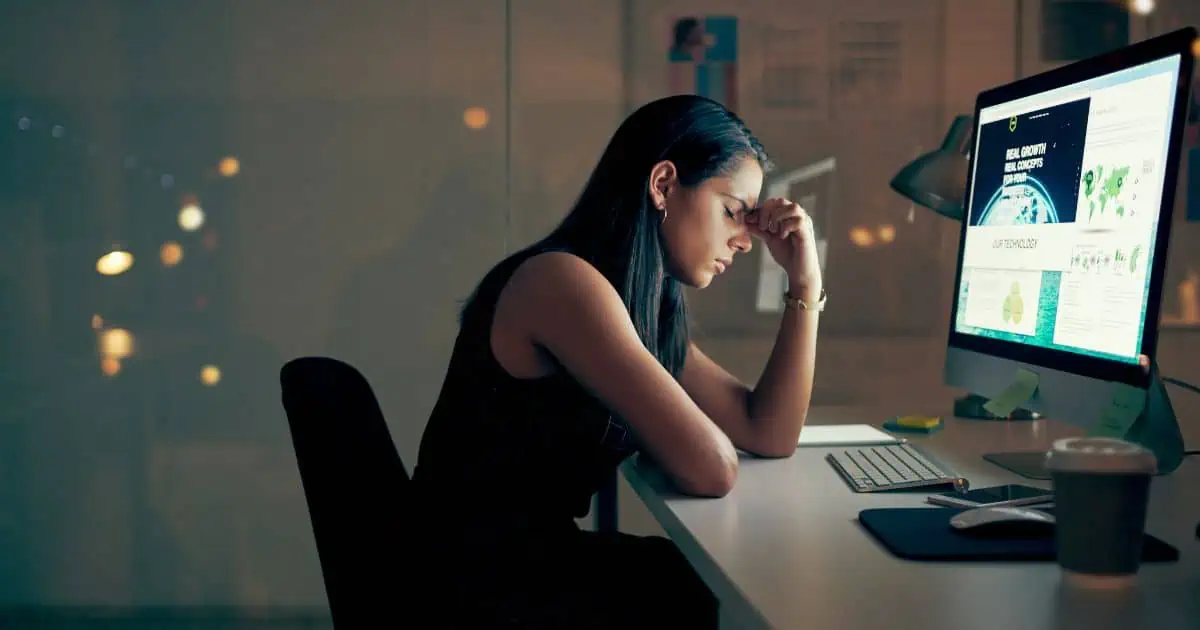 Woman sitting at desk suffering from stage 3 adrenal exhaustion
