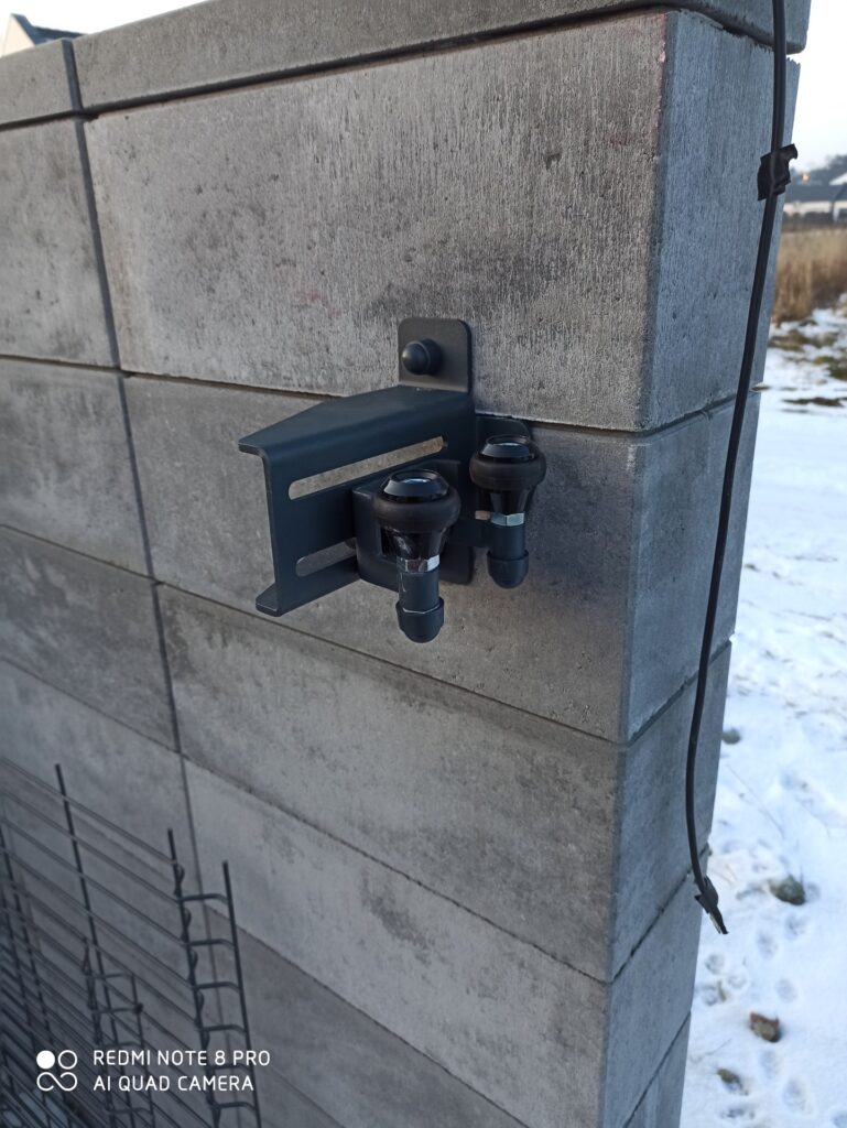 Zdjęcie przedstawia nowoczesne, solidne ogrodzenie palisadowe wykonane z metalu, zamontowane na betonowej ścianie. - ogrodzenie Metal-Serwis Obrzycko.