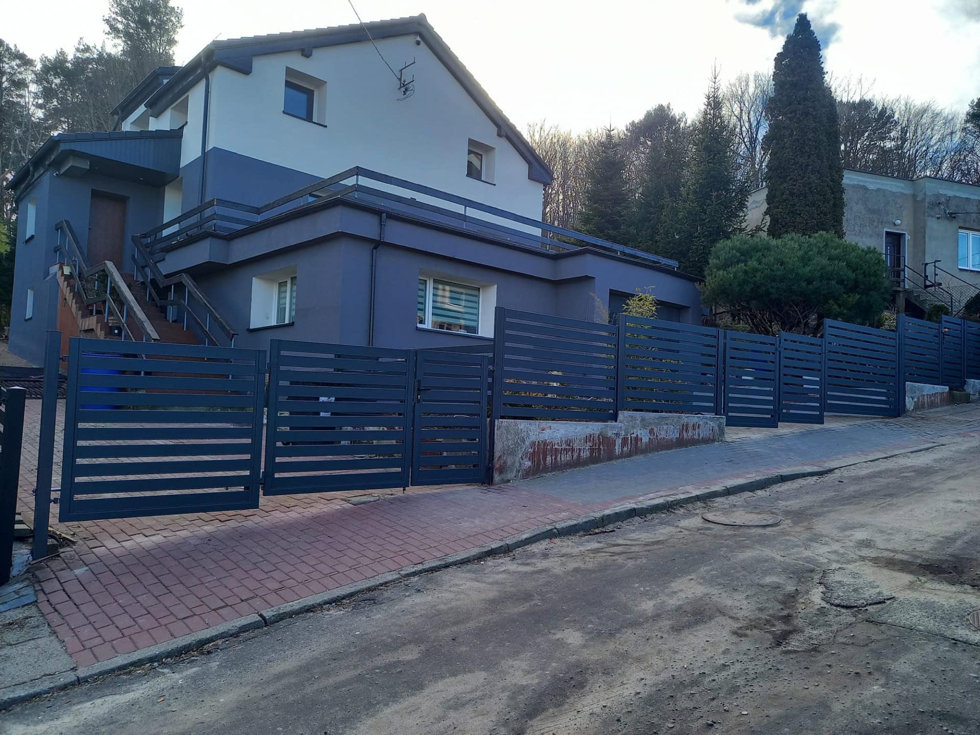 Nowoczesne, solidne ogrodzenie palisadowe z metalu, pomalowane na ciemny niebieski kolor - ogrodzenie Metal-Serwis Obrzycko.