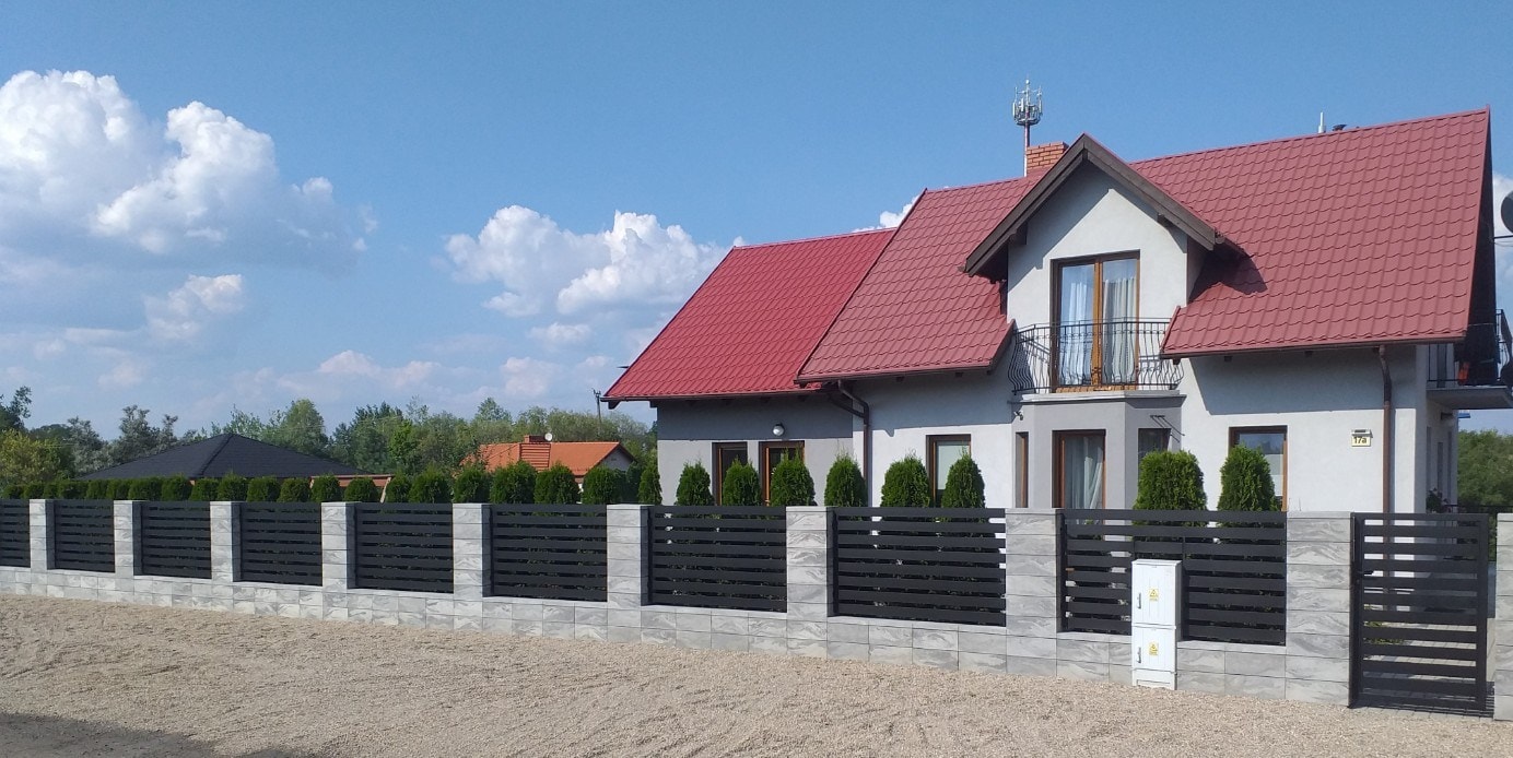 Przedstawione ogrodzenie panelowe z czarnych paneli metalowych, nowoczesne i solidne, zapewniające prywatność i bezpieczeństwo - ogrodzenie Metal-Serw.