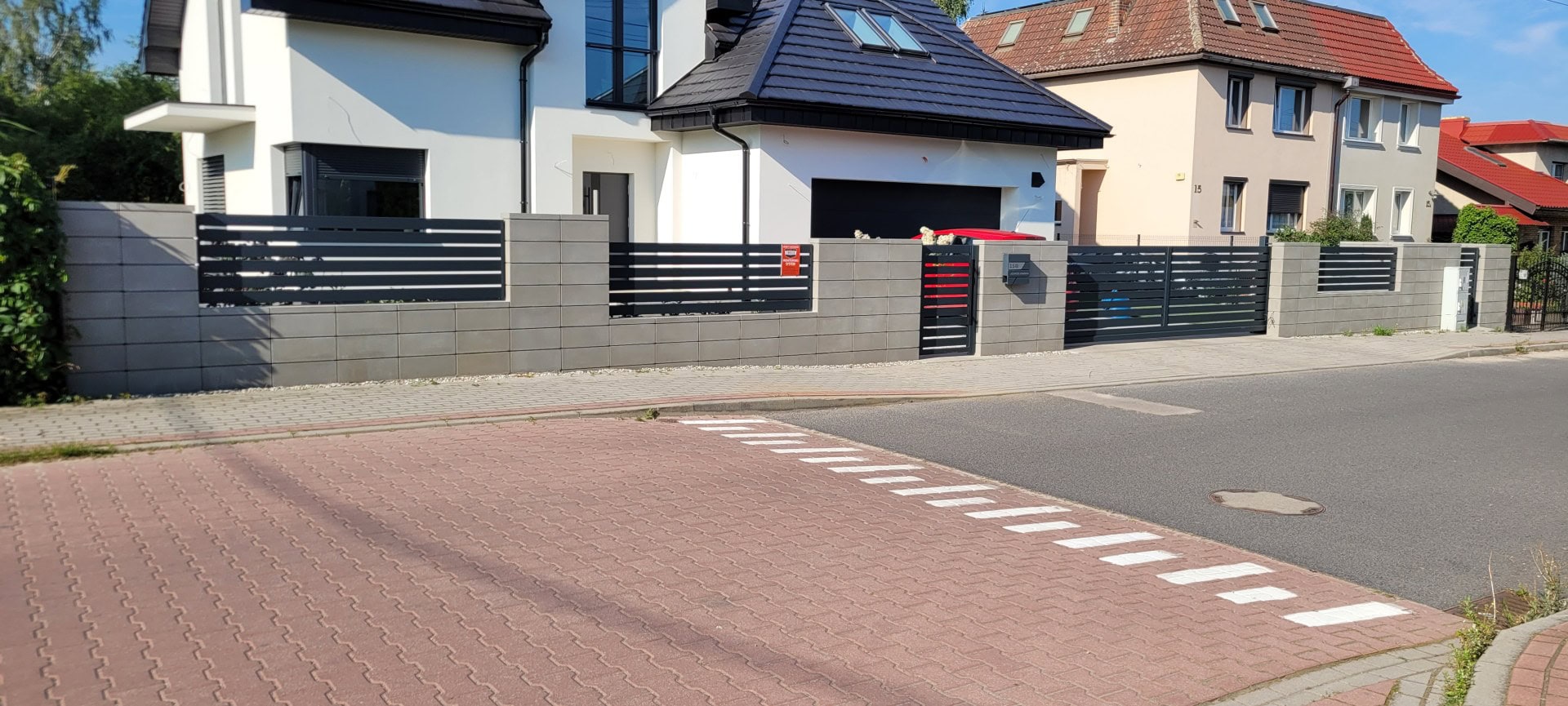 Przedstawione ogrodzenie palisadowe z czarnych paneli metalowych, idealne do nowoczesnych posesji - ogrodzenie Metal-Serwis Obrzycko.