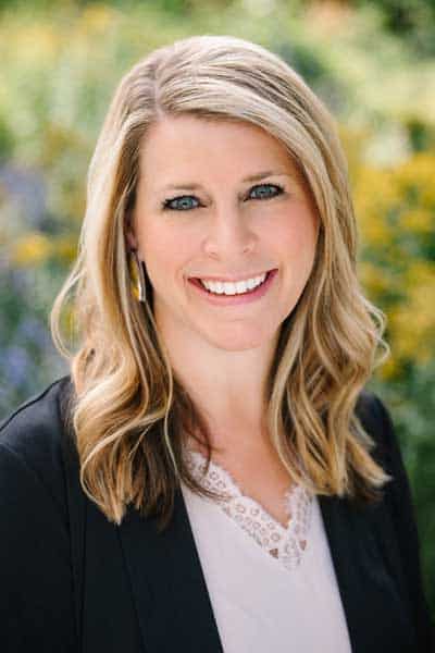 Professional woman smiling outdoors, representing health and wellness services.