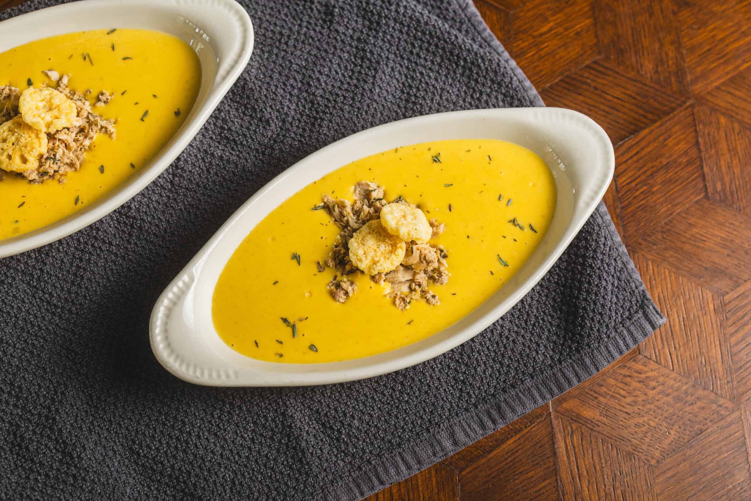 Creamy butternut squash soup topped with shredded chicken, croutons, and herbs in a white oval bowl. Perfect for warm, comforting meals and easy to prepare with fresh ingredients.
