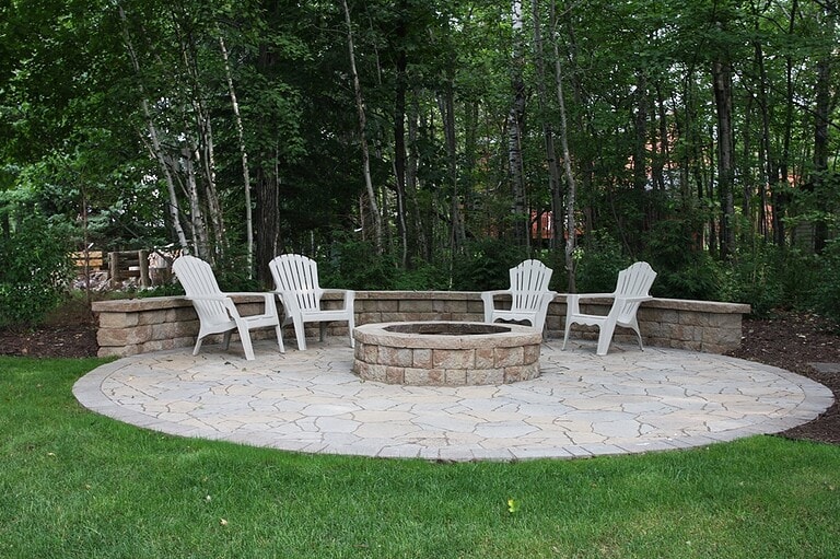 Fire pit in the shade with grass surrounding it