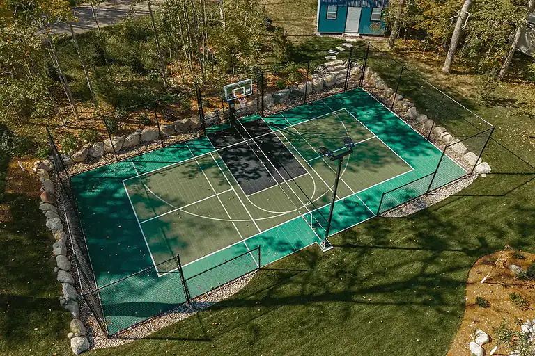 Aerial view of a new multi-sport court with basketball and tennis lines.