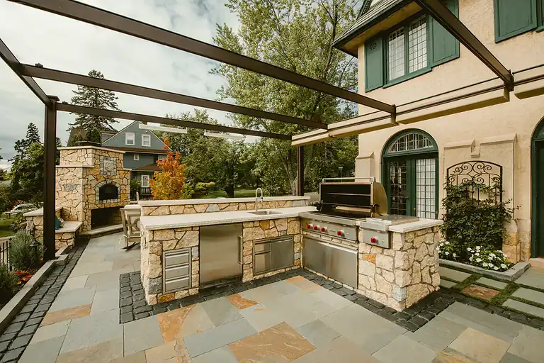 Outdoor kitchen featuring stone countertops, a built-in grill, and a spacious cooking area. Perfect.