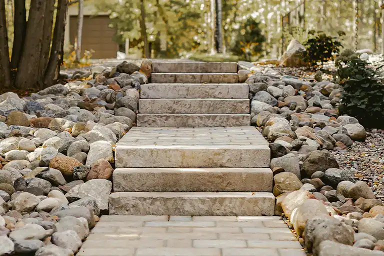 Stone staircase with landscaped rocks in a garden setting.