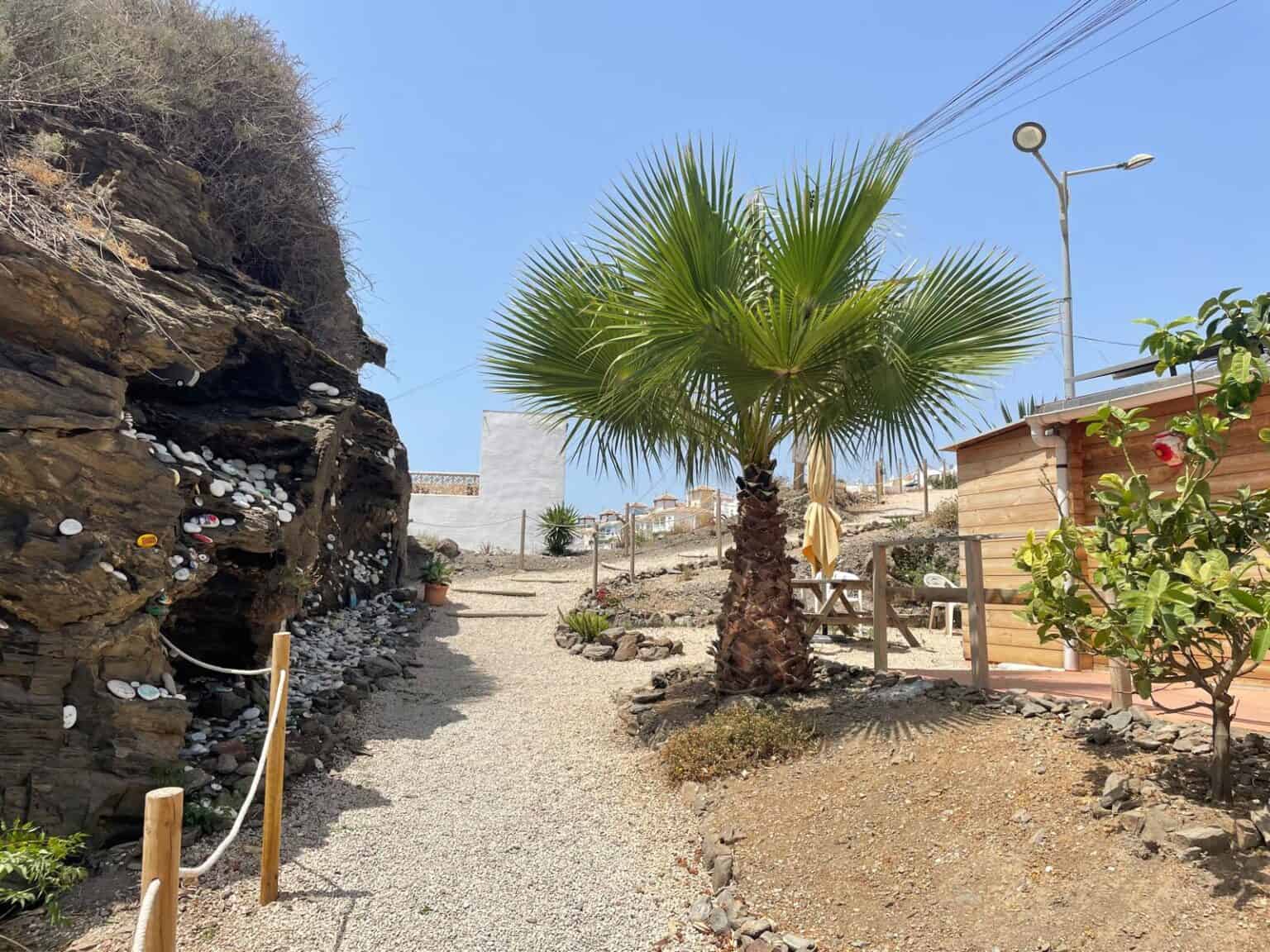 Área de camping en Torrox-Costa con palmeras y sendero de grava.