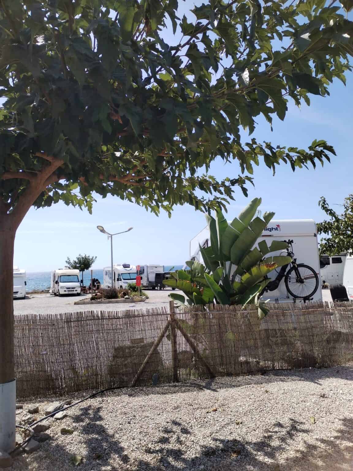Área de camping para autocaravanas en Torrox-Costa, con sombra y servicios cerca del mar.