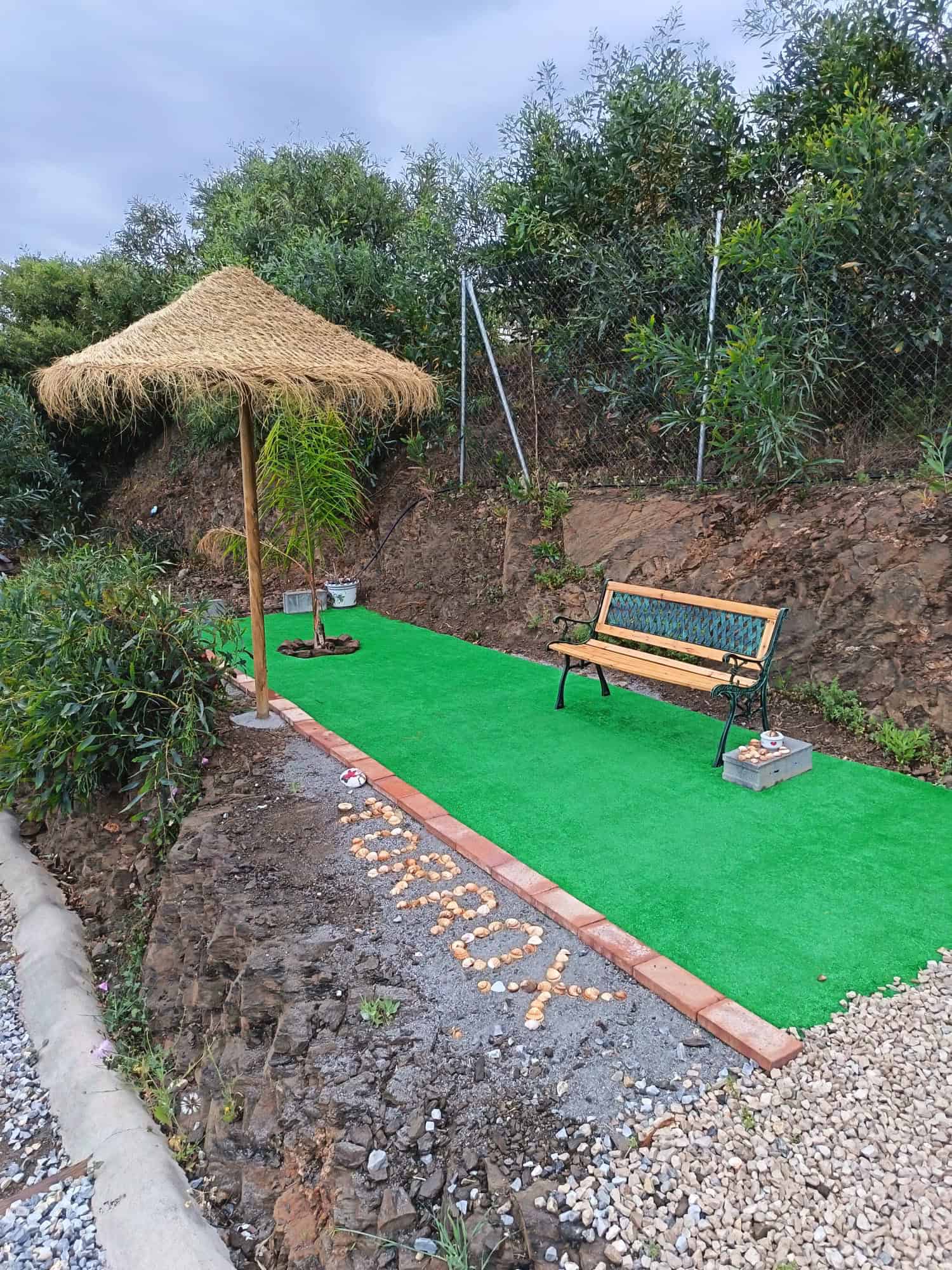 Zona de relax con banco y sombrilla en instalaciones de MiluCar Torrox-Costa.
