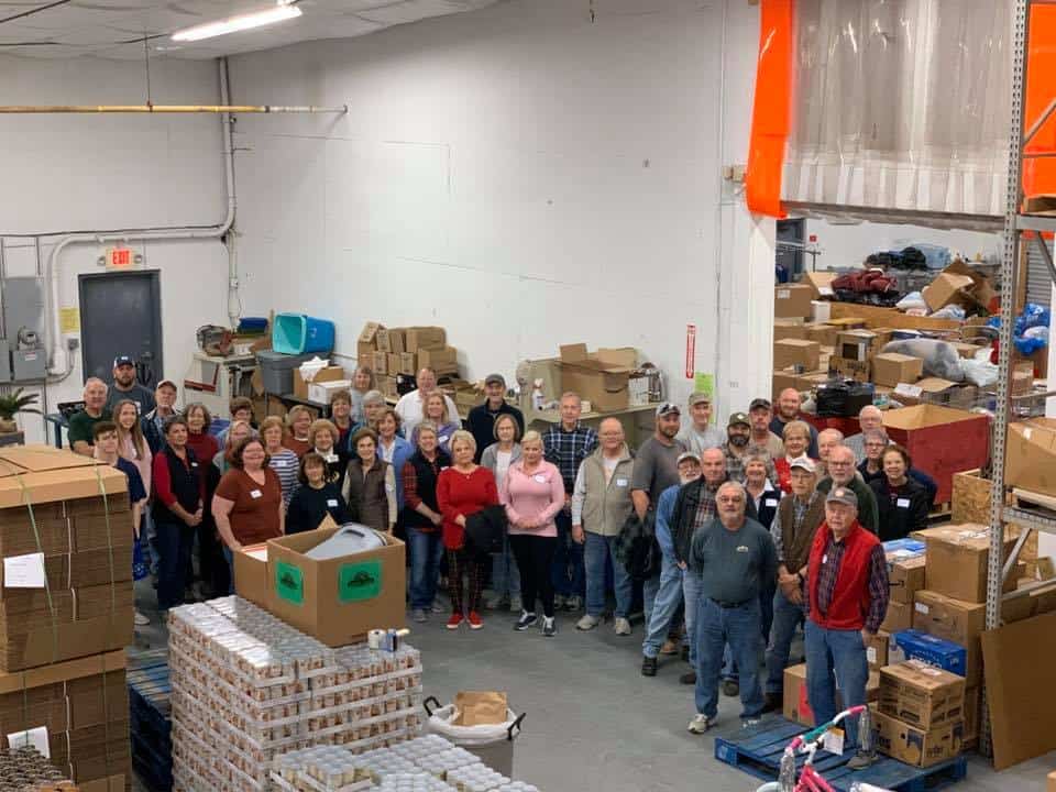 A group of people standing in a warehouse.