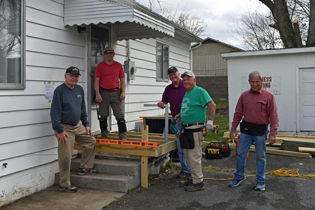 A group of men standing on the steps of a house.