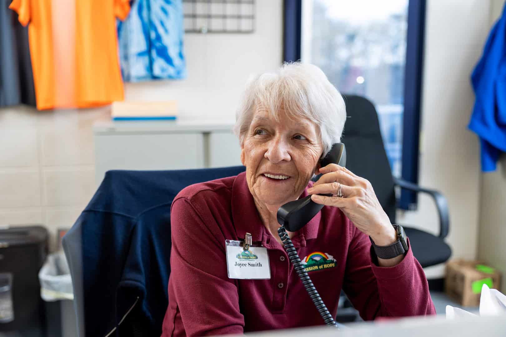 MOH_1920_306 An older woman talking on the phone at a desk. Striving to be the Hope of East TN.