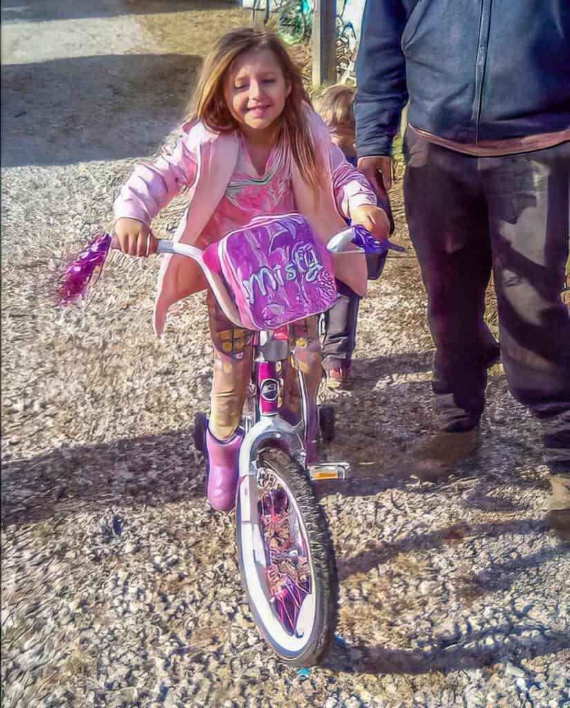 A little girl riding a bike.