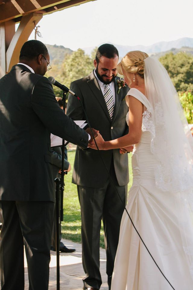 Bride and groom praying together with the groom's father, who officiated their wedding ceremony. Photo courtesy of David Mendoza III.