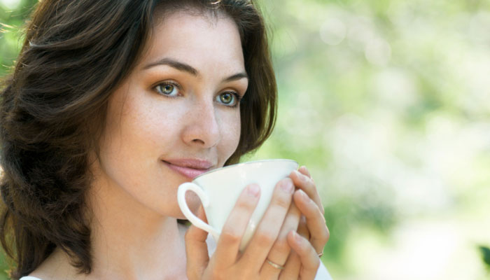 woman drinking cup of green tea