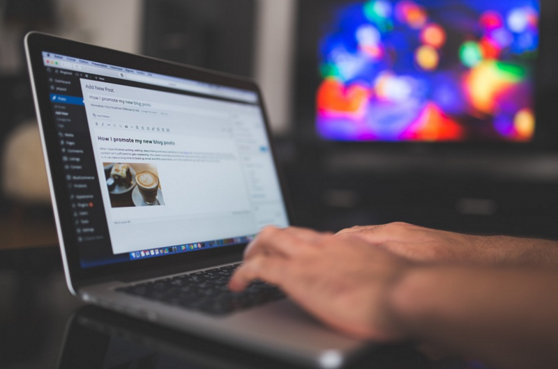 person typing on laptop for blog side hustle