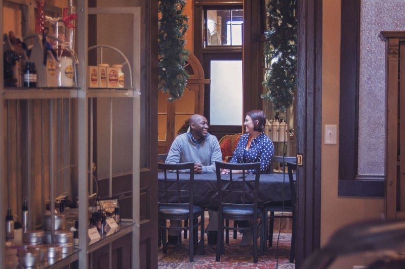 couple sitting at table laughing talking about why to live with your partner