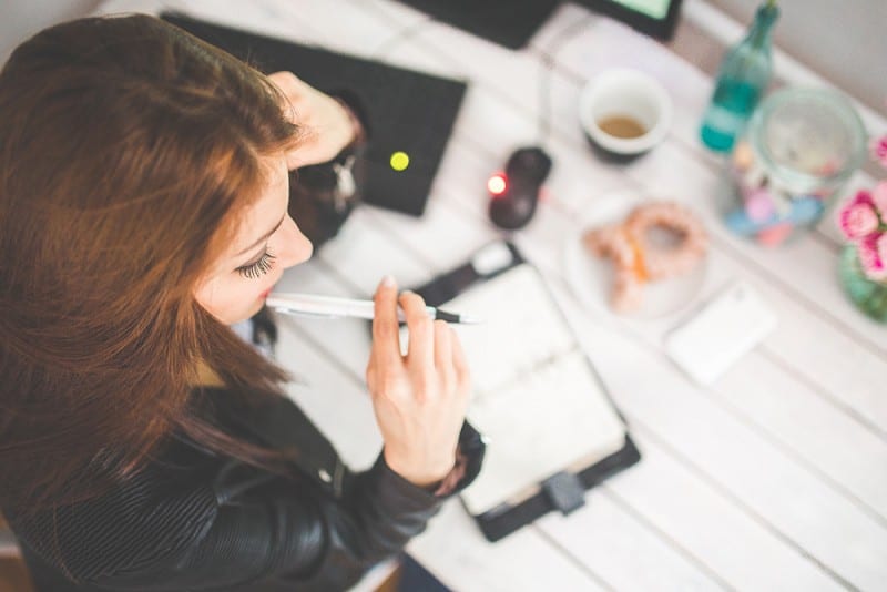 woman chewing on pen thinking about her lenten resolution