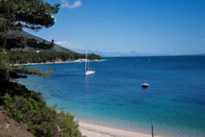 blue ocean water with sailboat taken while traveling right now