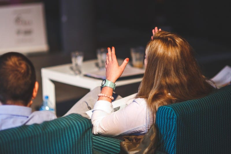 woman gesturing in meeting about how to boost your confidence