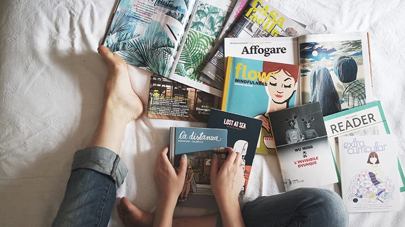 books spread out on bed are what you should be reading