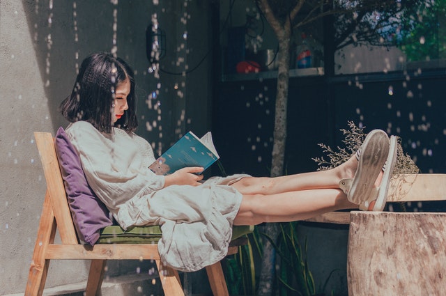 Photo by Min An from Pexels person relaxing outside and reading