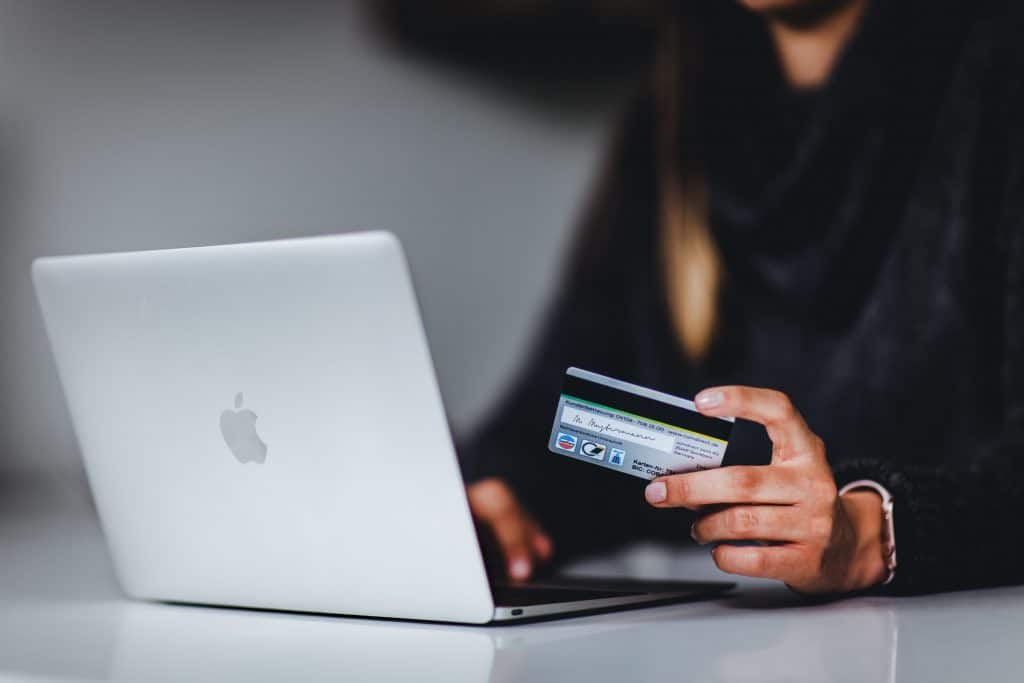 A person shopping at an online store with credit card in hand