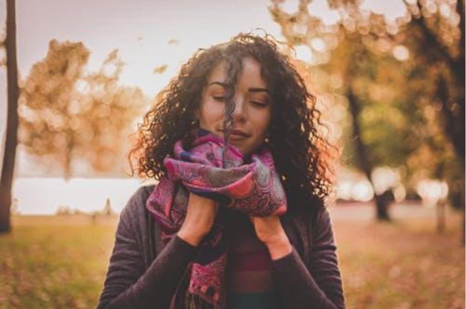A woman holding a purple scarf