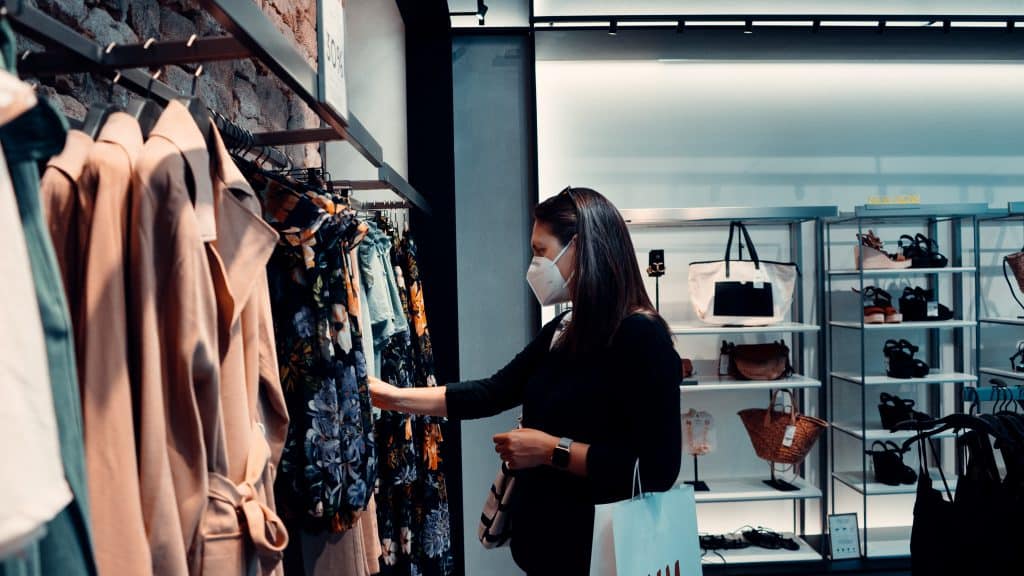 A woman shopping in a store while wearing a facemask