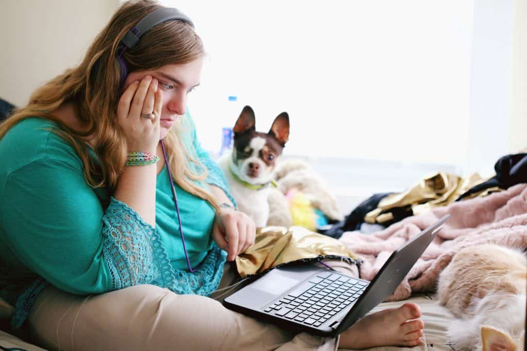 A woman trying to overcome her challenges while sitting on her bed with her pup